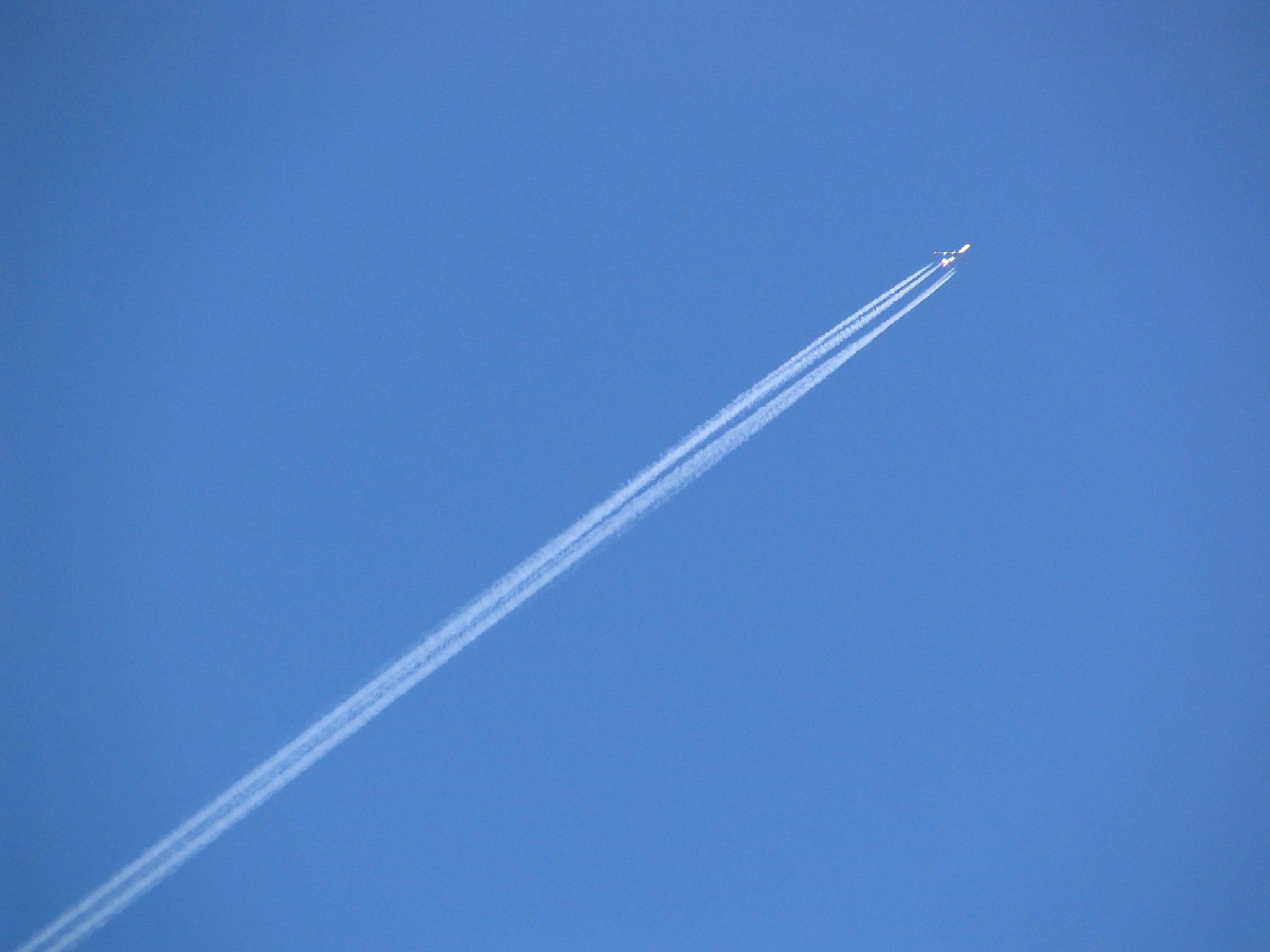 a white plane is flying through the sky