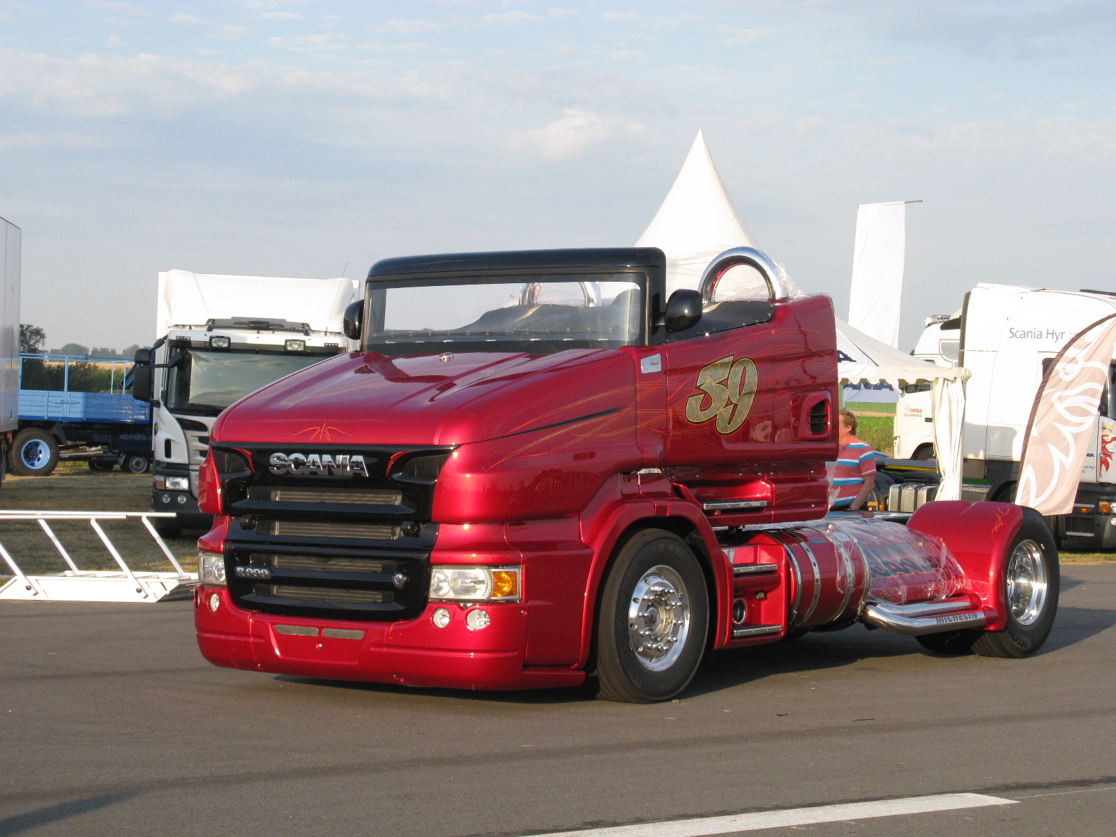 red semi truck with a black cab on a parking lot