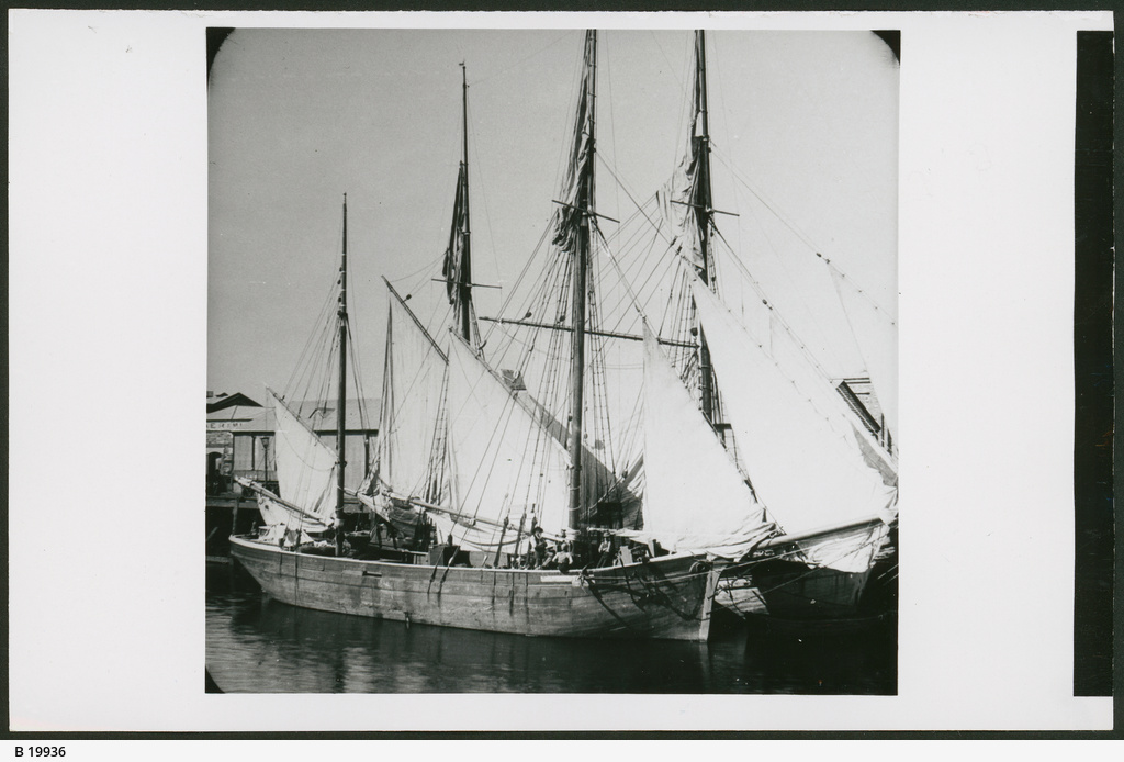 a large sailing vessel at the dock of a sea town