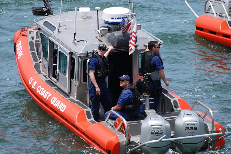 two men standing in the water on the back of a boat