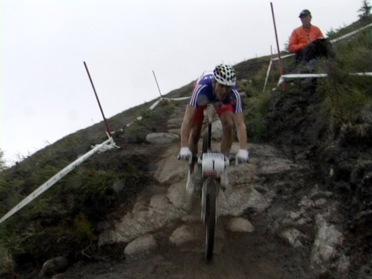 the bicyclist is riding on a narrow trail