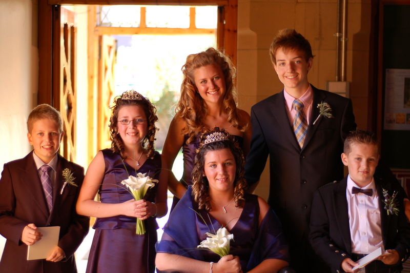 a young man posing for the camera with his bridesmaids