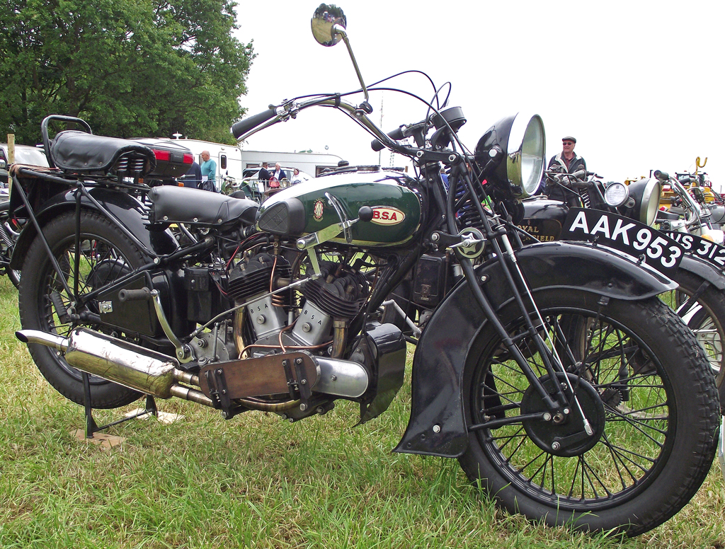 a vintage motorcycle on display in the grass