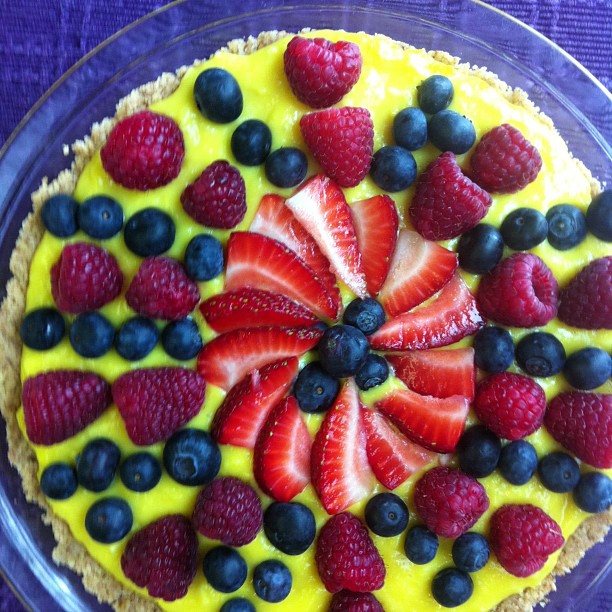 a plate of fresh fruit topped with a tart crust