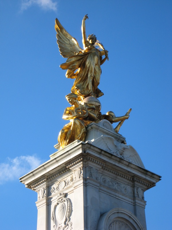 a gold and white statue atop a metal structure