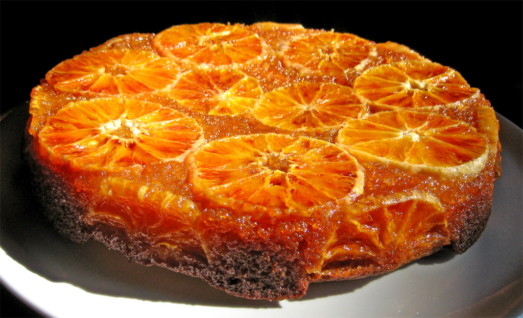 orange cake on a plate with syrup sprinkled on the top