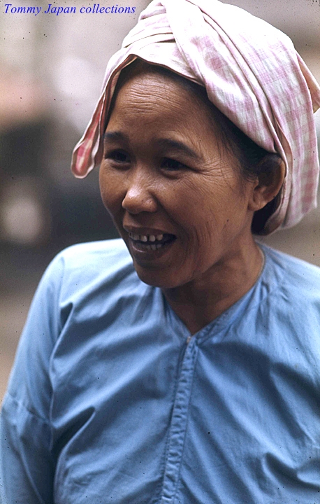 a smiling woman in an elaborate head scarf
