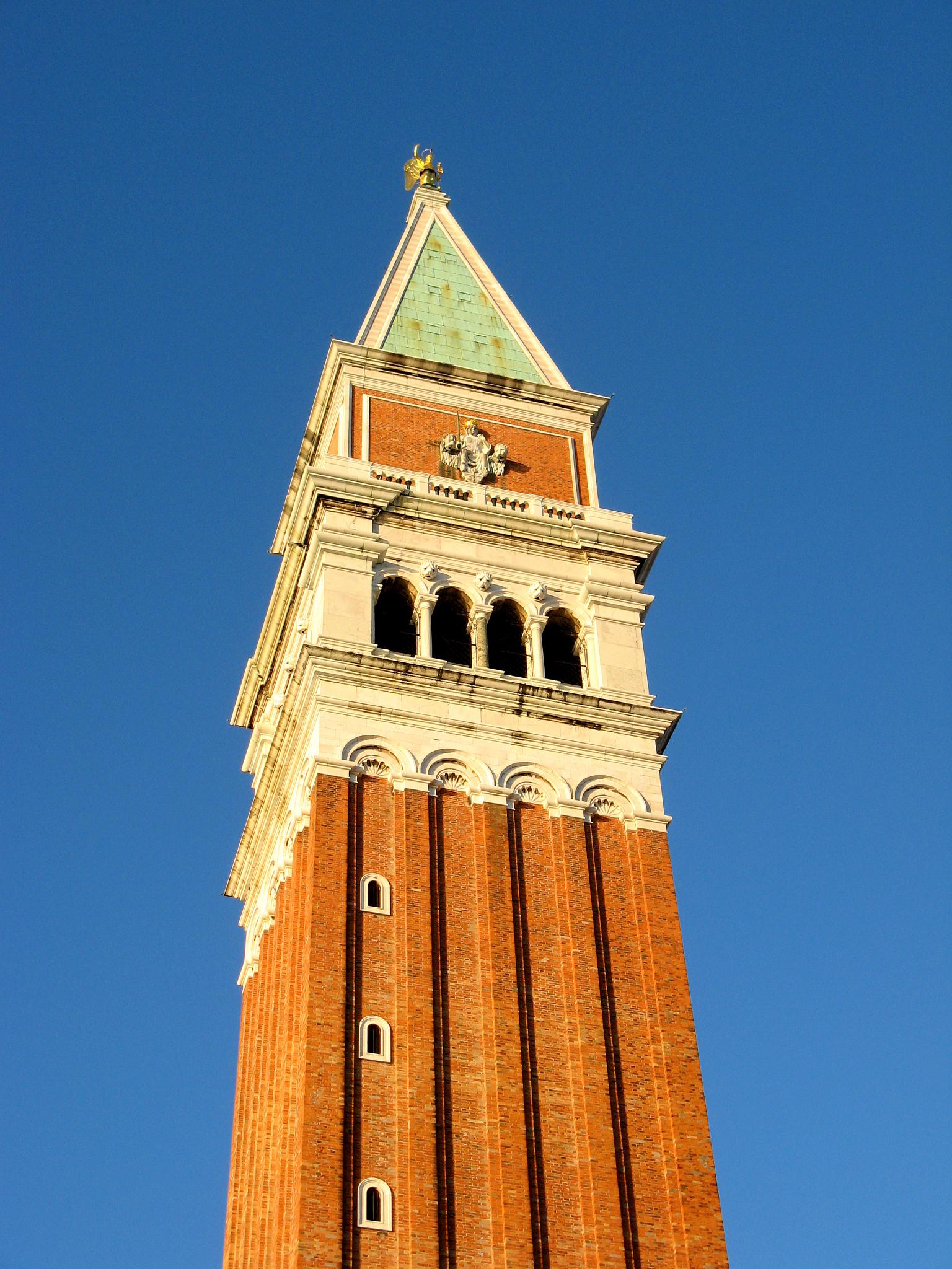 an ornate brick clock tower against a blue sky