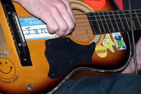 a man is holding a small guitar with an interesting sound