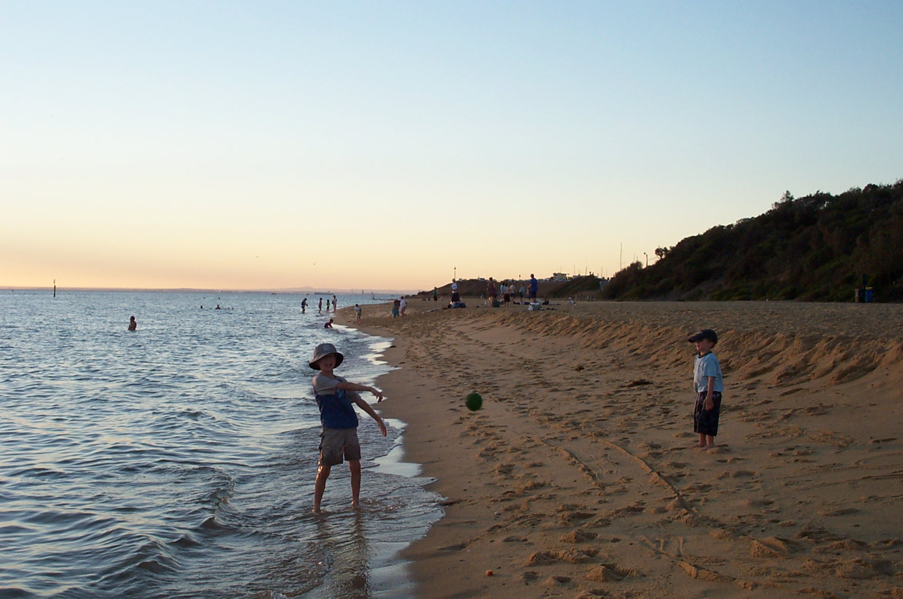 there is a young person flying a kite at the beach