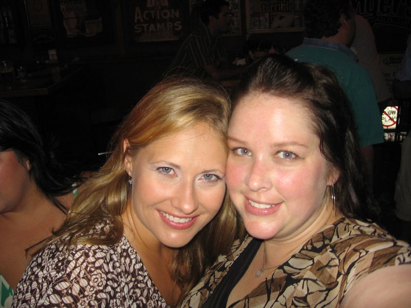 two women are posing for the camera in a bar