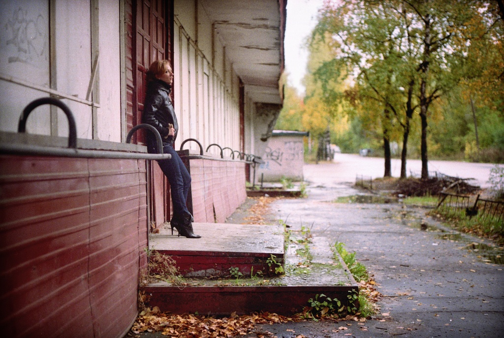 the woman sits on a ledge outside a building