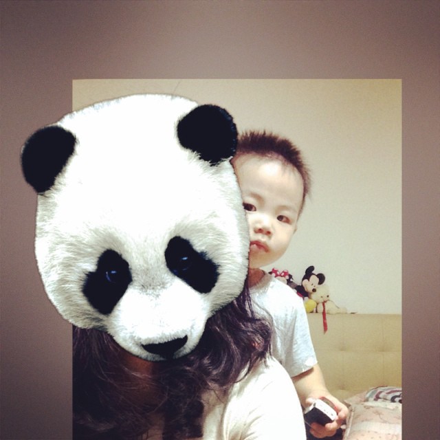 a child is holding a panda bear up to its face
