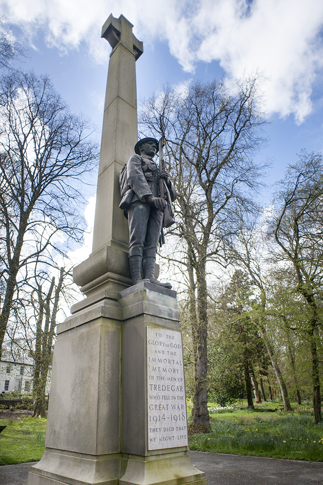 a statue stands in the middle of a park