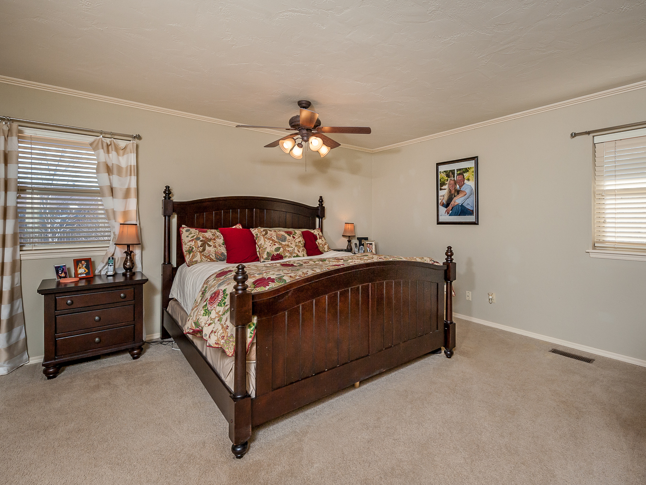 a large bedroom has carpet and ceiling fans