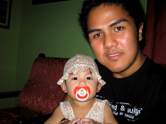 a man holding a baby wearing a pacifier in his mouth