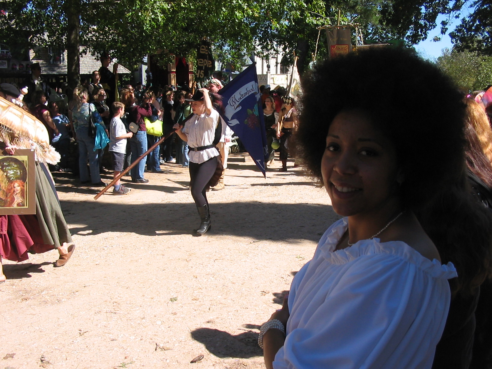 a woman wearing a white shirt standing next to some people