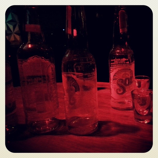 three empty bottles sitting next to each other on a table