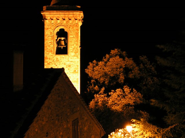 church bell tower lit up at night with bright lights