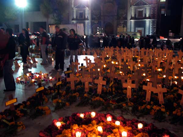 a group of people standing near crosses and candles