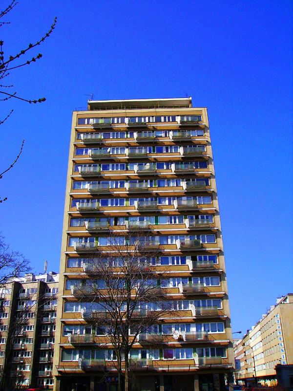 building with large windows near sidewalk and trees