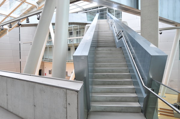 two escalators with a metal railing are leading to the top floor