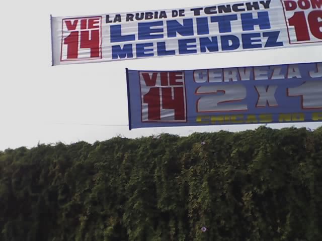 advertising sign above some bushes for a tennis tournament