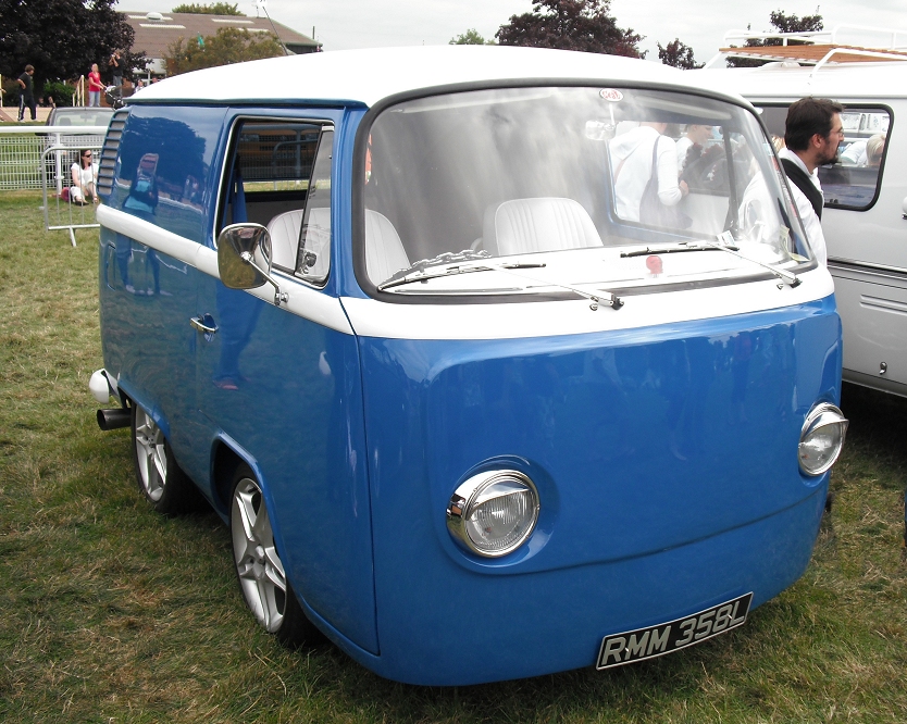 a blue and white van with people standing around