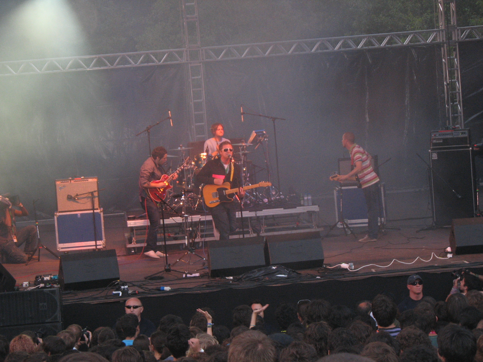 the band perform at an outdoor concert on stage