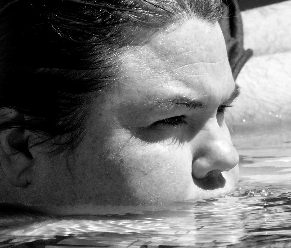 black and white image of a girl in a swimming pool