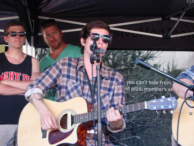 a man holding a guitar while playing music