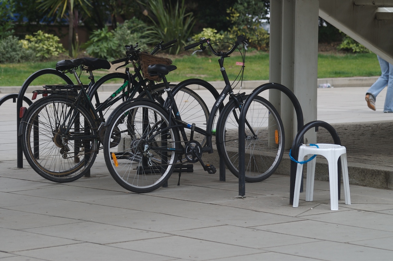 four bicycles are sitting next to each other on the sidewalk