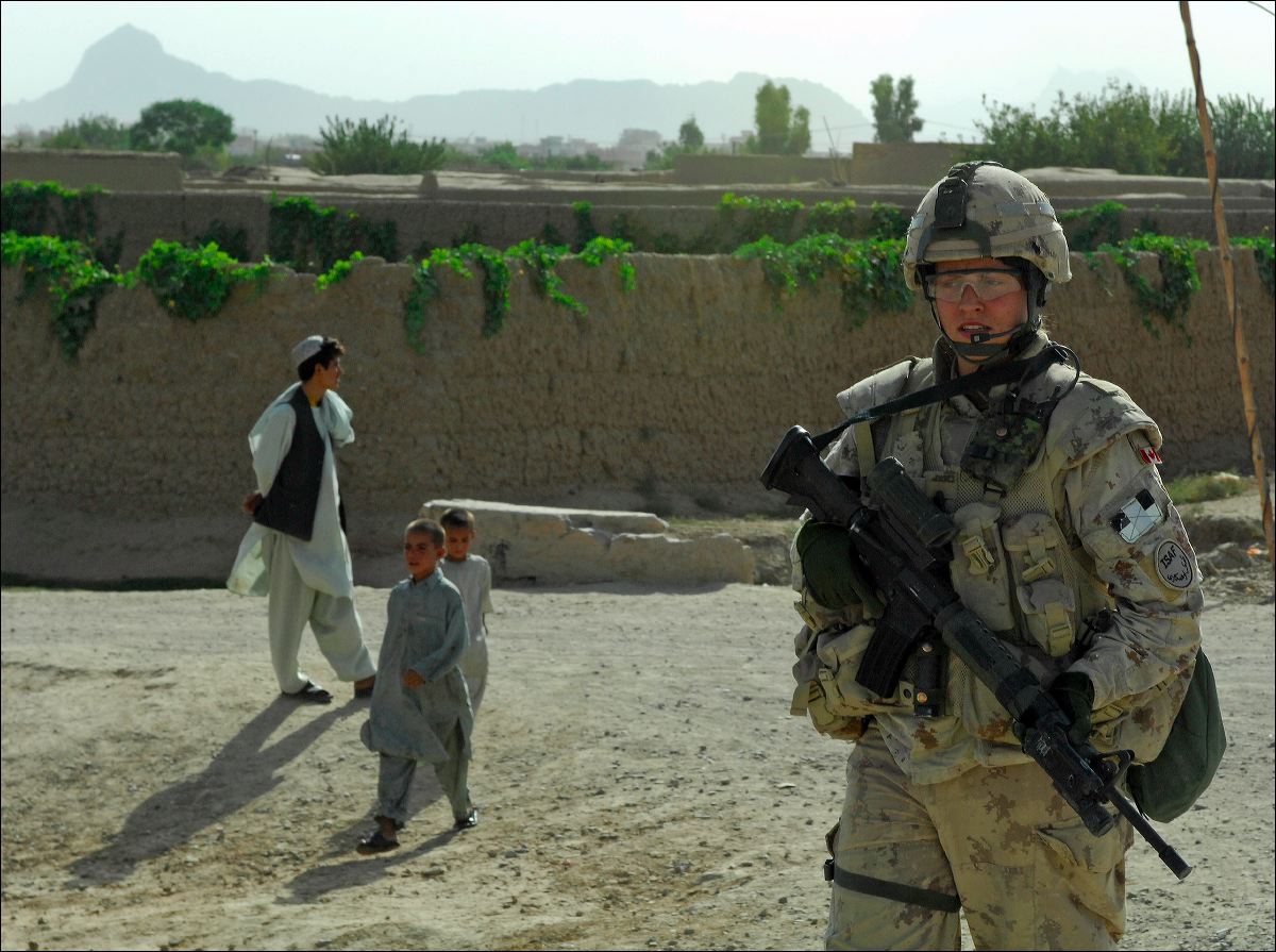 a soldier is walking through the desert with other people