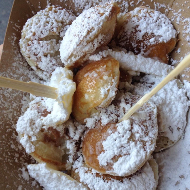 several pastries and powdered sugar sitting in a brown box