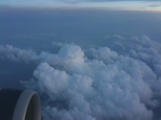 a sky view of the clouds above an airplane wing