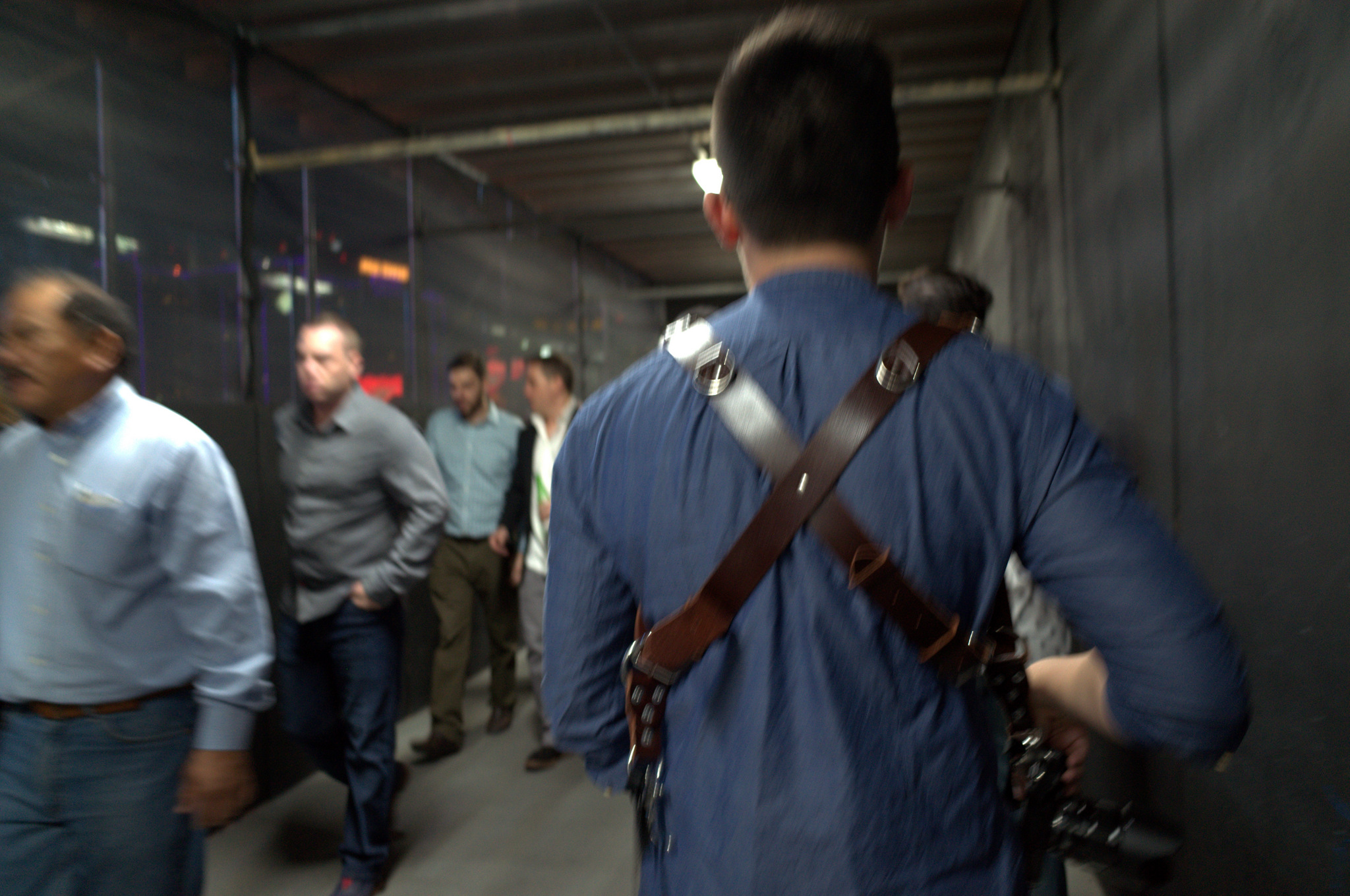 a man in suspenders with his camera and backpack