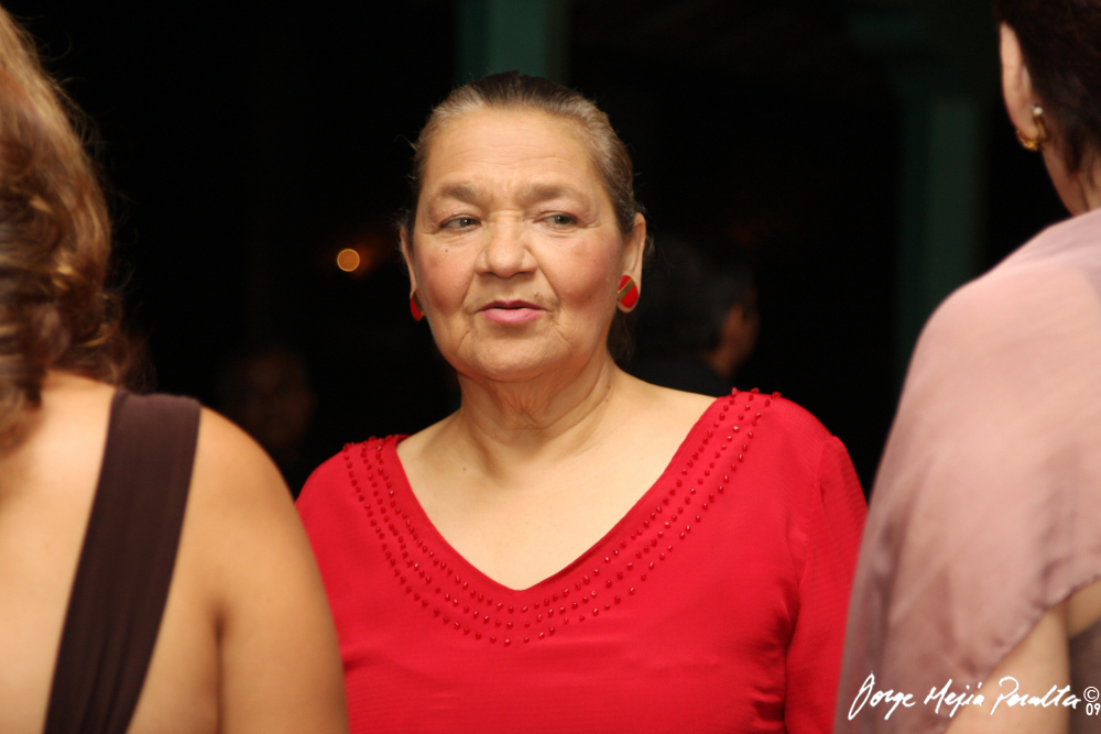 a woman in a red top looks over her shoulder