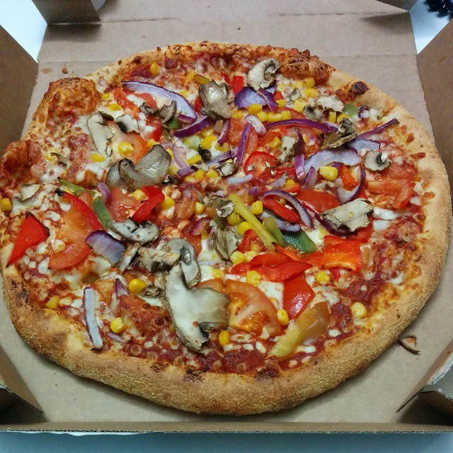 a pizza with many vegetables in a box