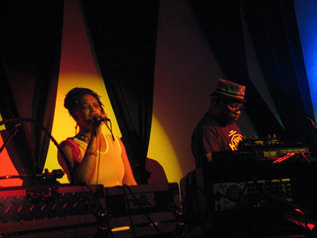 two people on stage with keyboards and microphone