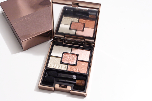an opened box with a compact shadow and eye shadow