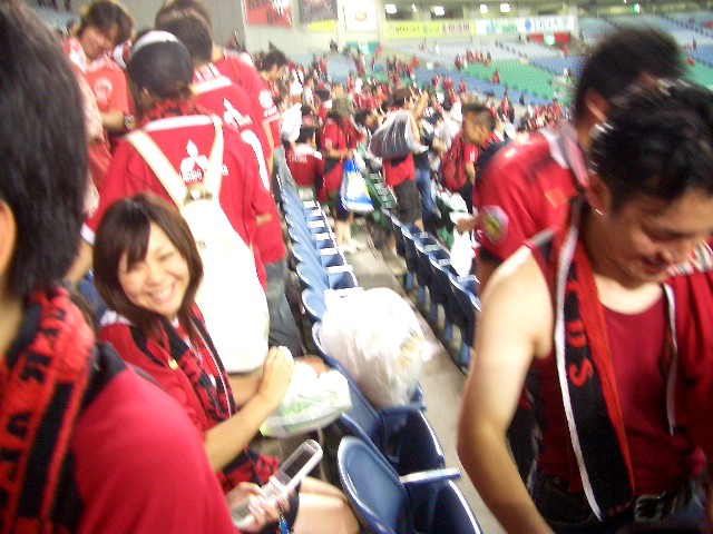 a crowd of people in red shirts sitting at a sporting event