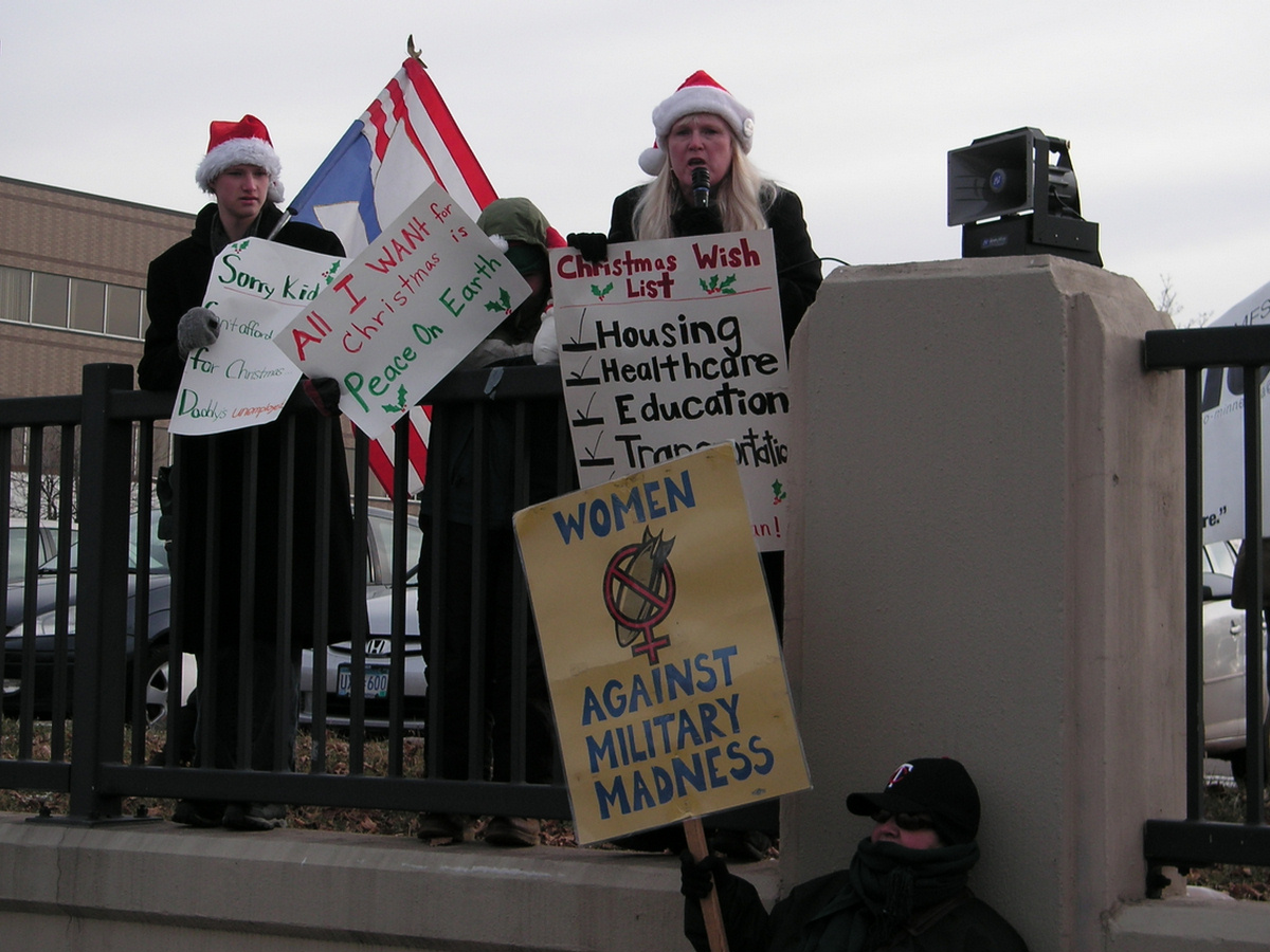 some protesters hold signs and sing on the railing