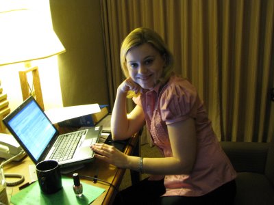 a woman sitting in front of a laptop on a desk