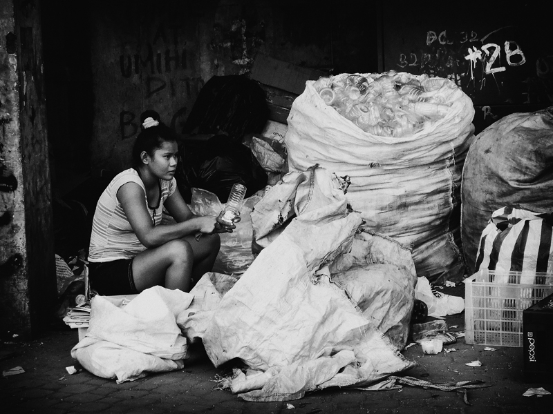 black and white pograph of woman sitting near bags of food