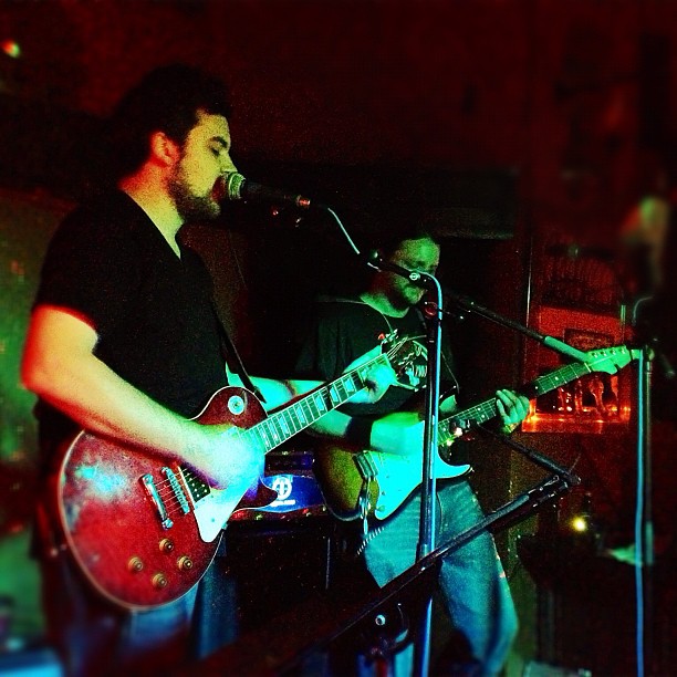 a man on a stage playing a guitar and singing