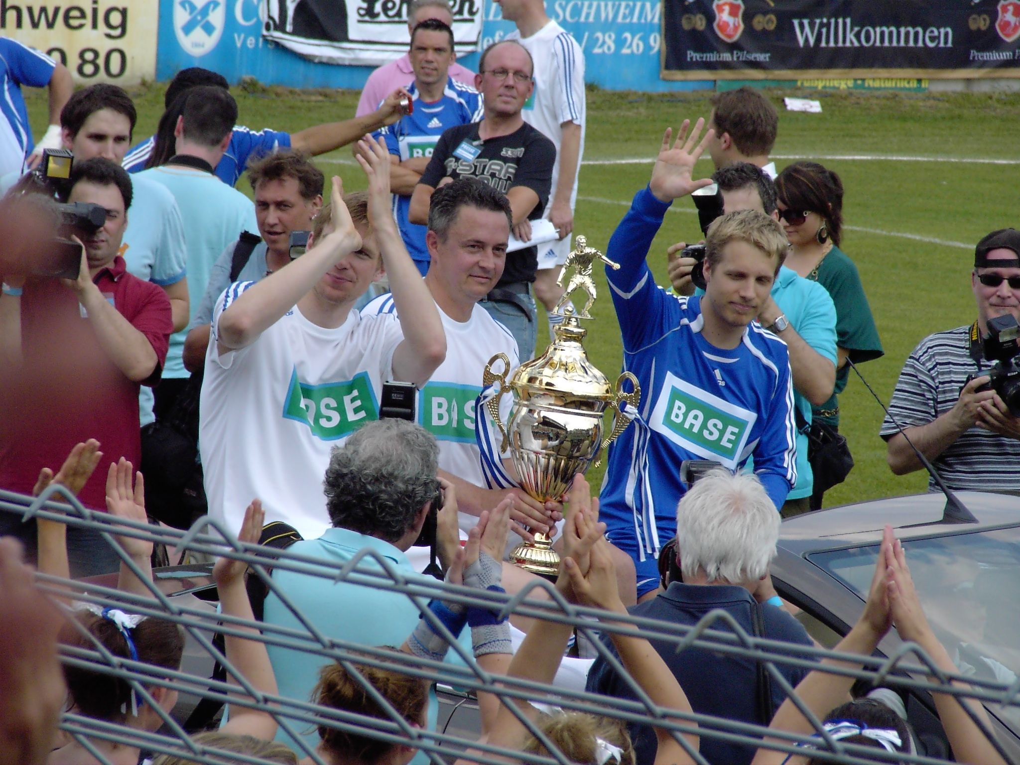 the men are celeting and holding their trophy