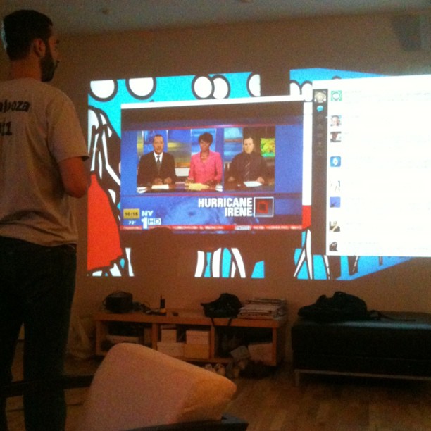 a man stands in front of the television and watches the screen