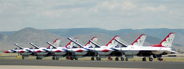 red, white and blue airplanes lined up for takeoff