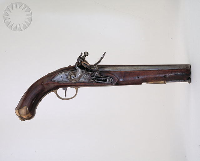a wooden colt gun in the middle of the wall