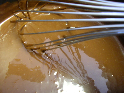 chocolate and a whisk sit in an ointment with liquid